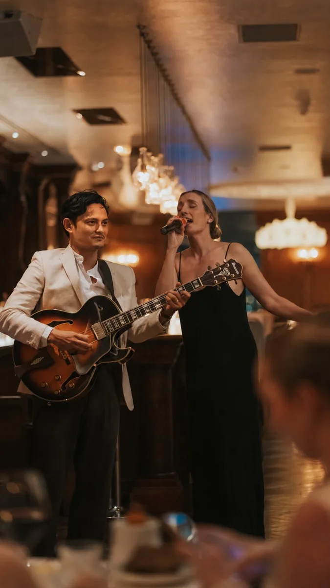 Jazz singer and guitarist performing in a restaurant setting, from The Albion Friday jazz announcement.