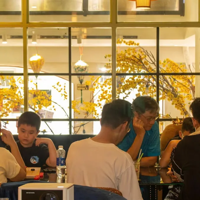 People conversing at Myths cafe, used as event-page imagery for the language exchange.