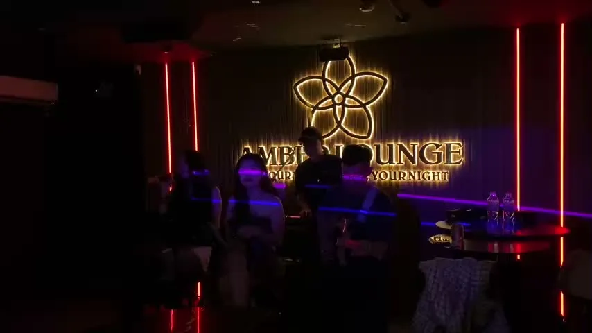 Amber Lounge interior with stage lights, guests, and the venue sign during a Saturday live music reel.